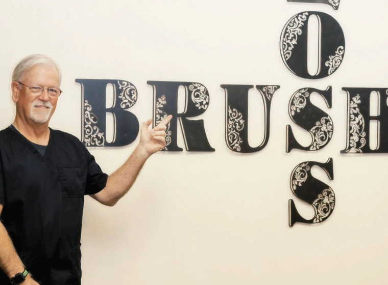 dentist pointing at sign